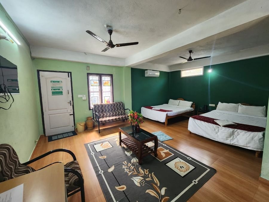 Family room with two double beds, a sofa, coffee table and ceiling fans